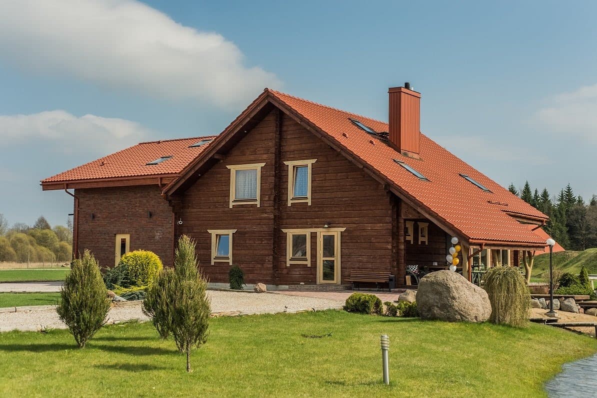 A timber lodge with a red tiled roof at Grand Vila